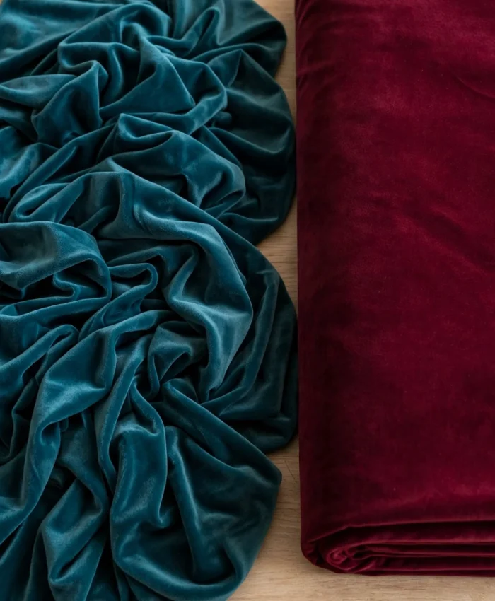 Stretch velvet in teal beside structured royal velvet in burgundy